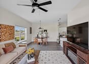 Thumbnail 9 of 26 - A living room with a couch, a coffee table, and a ceiling fan.