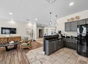 Thumbnail 7 of 25 - A modern kitchen with black appliances and wooden floors.