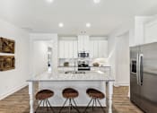Thumbnail 7 of 26 - a kitchen with a marble counter top and three stools