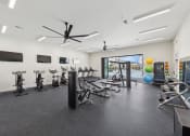 Thumbnail 32 of 36 - a gym with treadmills and other exercise equipment in a building with a window