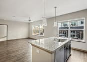 Thumbnail 31 of 39 - A kitchen with a granite countertop and a window overlooking a cityscape.