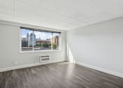 Thumbnail 8 of 13 - A room with a window overlooking a cityscape.