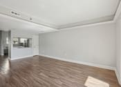 Thumbnail 8 of 27 - A room with wooden flooring and white walls.