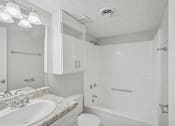 Thumbnail 11 of 11 - A white bathroom with a sink, toilet, and bathtub.