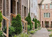 Thumbnail 143 of 149 - A row of houses with green trees in front.