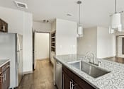 Thumbnail 36 of 39 - A kitchen with a refrigerator, sink, and cabinets.