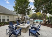 Thumbnail 33 of 47 - an outdoor patio with blue chairs and a fire pit