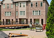 Thumbnail 137 of 149 - A brick building with a balcony and chairs in front.