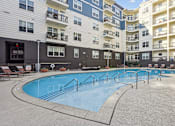 Thumbnail 22 of 39 - A large outdoor swimming pool surrounded by apartment buildings.