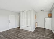 Thumbnail 10 of 13 - A kitchen area with a white fridge, white cabinets, and a white door.