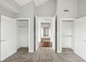 Thumbnail 12 of 13 - A hallway with white walls and a carpeted floor.