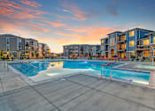 Thumbnail 15 of 32 - A large swimming pool surrounded by apartment buildings.