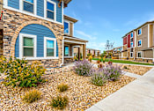 Thumbnail 22 of 32 - A blue house with a gravel garden in front.