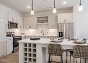 Thumbnail 18 of 29 - A modern kitchen with a white island and chairs.