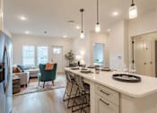 Thumbnail 16 of 29 - A modern kitchen with a dining area and a refrigerator.