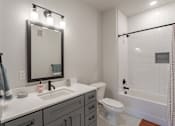 Thumbnail 21 of 29 - A bathroom with a white sink and a white toilet.