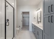 Thumbnail 23 of 29 - A bathroom with a walk-in shower, toilet, and sink.