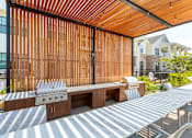 Thumbnail 26 of 35 - A wooden grill is on a patio with a grill cover.