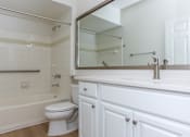 Thumbnail 24 of 36 - A white bathroom with a toilet, sink, and bathtub.