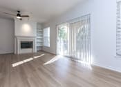 Thumbnail 13 of 36 - A spacious living room with a fireplace and sliding glass doors.