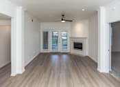 Thumbnail 21 of 36 - A spacious room with a ceiling fan and a fireplace.