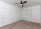 Thumbnail 23 of 36 - A room with a ceiling fan and a door.