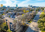 Thumbnail 16 of 21 - A cityscape with buildings and trees in the foreground.
