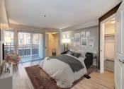 Thumbnail 8 of 34 - a bedroom with a bed and a door to a balcony