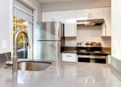 Thumbnail 11 of 34 - a kitchen with a sink stove and refrigerator