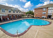 Thumbnail 52 of 65 - A swimming pool in a residential area surrounded by houses.