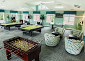 Thumbnail 49 of 65 - A room with a foosball table and a pool table.