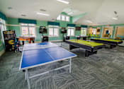 Thumbnail 35 of 65 - A room with a ping pong table and a foosball table.