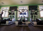 Thumbnail 36 of 65 - Three treadmills are lined up in a row in a room.