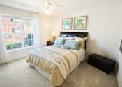 Thumbnail 60 of 65 - A bedroom with a bed, nightstand, and window.