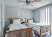 Thumbnail 38 of 41 - A bedroom with two beds and a ceiling fan.