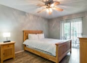 Thumbnail 40 of 41 - A bedroom with a bed, nightstand, and a ceiling fan.