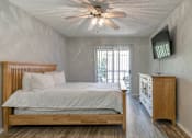 Thumbnail 39 of 41 - A bedroom with a bed, a dresser, and a ceiling fan.