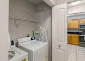 Thumbnail 41 of 41 - A white washing machine and dryer in a small laundry room.