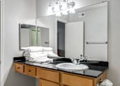 Thumbnail 35 of 41 - A bathroom with a sink, mirror, and towel stack.