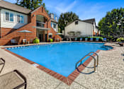 Thumbnail 2 of 41 - A swimming pool surrounded by a brick border and lounge chairs.