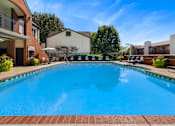 Thumbnail 3 of 25 - A large blue swimming pool in front of a building.