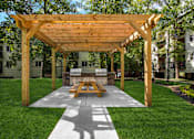 Thumbnail 5 of 41 - A wooden pavilion with a picnic table in the middle of a grassy area.