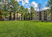 Thumbnail 7 of 41 - A grassy area in front of apartment buildings.