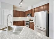 Thumbnail 28 of 48 - a kitchen with stainless steel appliances and granite counter tops
