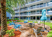 Thumbnail 21 of 24 - a patio with chairs and an umbrella outside of a building
