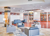 Thumbnail 18 of 24 - a lobby with couches and chairs and a table