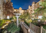 Thumbnail 38 of 39 - a view of a garden with a bridge and buildings at night