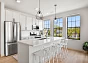 Thumbnail 26 of 53 - A modern kitchen with white cabinets and a large island.