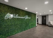 Thumbnail 22 of 61 - a lobby with a green wall with a welcome sign on it
