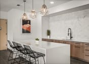 Thumbnail 31 of 61 - a kitchen with a white counter top and black chairs